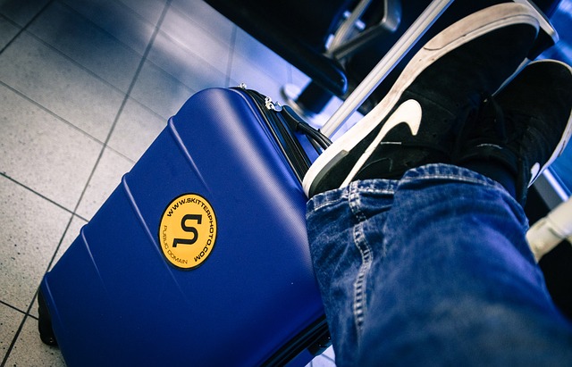 Cestovný kufor na letisku, vyložené nohy, oddych